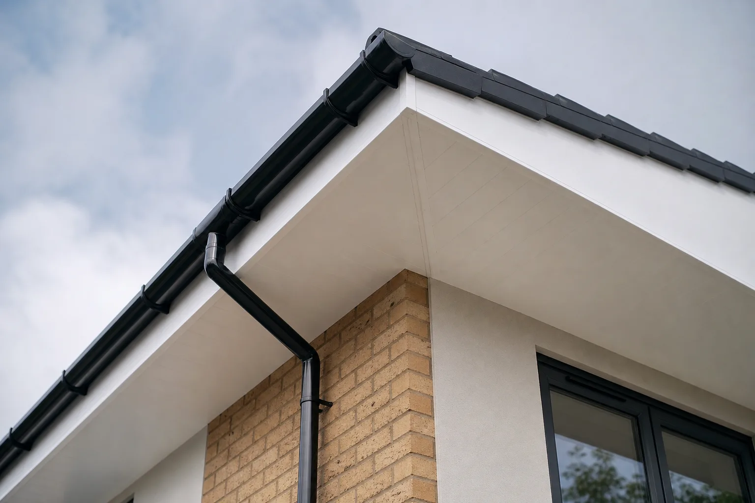 Freshly installed white uPVC fascias and soffits along the roofline of a house