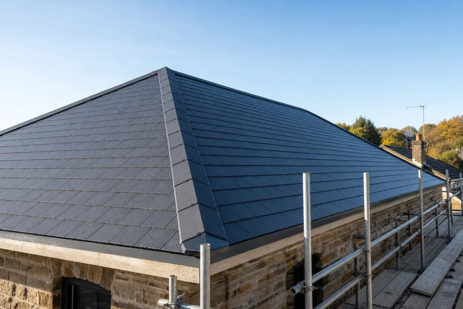 Newly installed grey slate pitched roof on a Leicestershire home against a clear sky